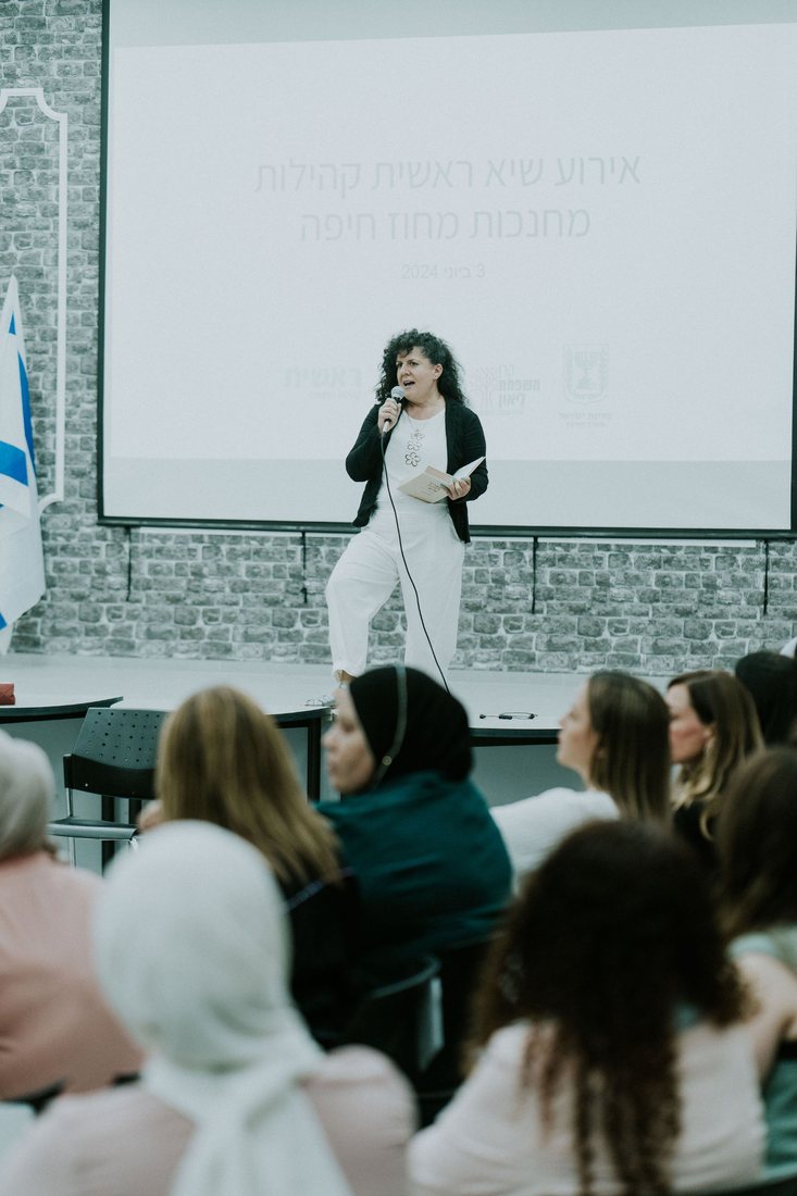 שירה כהן מרצה מול קהל באירוע קהילות מחנכות